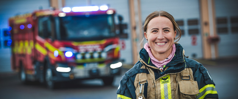 Porträttbild av Emelie Ullberg framför en brandbil