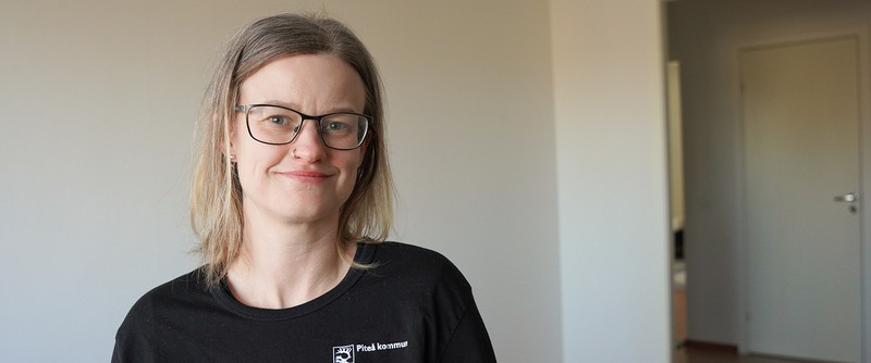 bild på Elise som ler och tittar i kameran. Hon har en svart tröja med Piteå kommuns logotype.