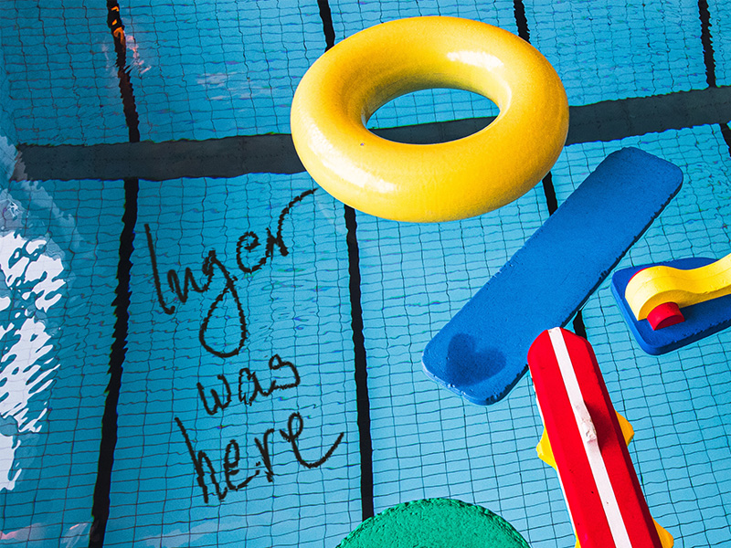 Installationsbild badbassäng med flytleksaker och texten Inger was here i bassängbotten.