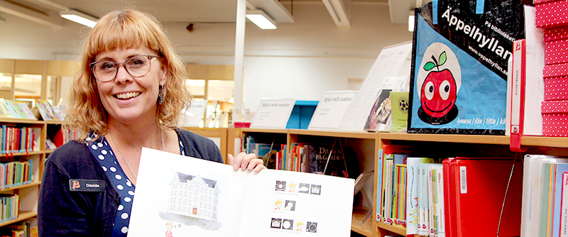 Desirée Stensdotter visar barnlitteratur i Äppelhyllan – för barn med läs- och skrivsvårigheter.