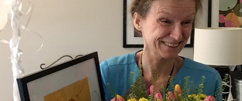 Annica Forsberg tar emot omsorgspriset som består av blommor, diplom och ballonger.