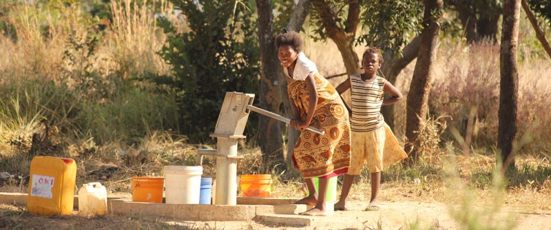 Barn vid vattenpump i Zambia