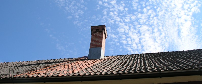 Skorsten, tegeltak och blå himmel